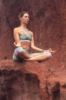Woman doing yoga on rock: cancer prevention education through lifestyle training