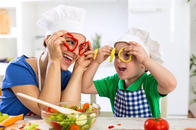 Setting Up Your Kid for Healthy Eating Habits - happy family playing with vegetables in kitchen